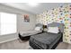 Bright bedroom with twin beds, colorful accent wall, and natural light from the window at 4457 Le Reve Ct, Kissimmee, FL 34746