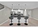 Modern kitchen featuring stainless steel appliances, a black countertop island with seating, and sleek white cabinetry at 4457 Le Reve Ct, Kissimmee, FL 34746