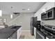 Well-equipped kitchen featuring stainless steel appliances, a black countertop and white cabinets, ideal for modern living at 4457 Le Reve Ct, Kissimmee, FL 34746