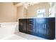 Bathroom featuring a double vanity with dark cabinetry, a tub, and tiled floors at 7700 Carriage Homes Dr # 4, Orlando, FL 32819