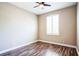A bedroom features wood flooring, a ceiling fan, and a window with plantation shutters at 7700 Carriage Homes Dr # 4, Orlando, FL 32819