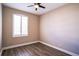 A bedroom features wood flooring, a ceiling fan, and a window with plantation shutters at 7700 Carriage Homes Dr # 4, Orlando, FL 32819
