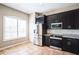 This kitchen features dark cabinetry, stainless steel appliances, and a window with plantation shutters at 7700 Carriage Homes Dr # 4, Orlando, FL 32819