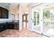 A kitchen featuring dark cabinetry, a stainless steel sink, and access to an outdoor balcony at 7700 Carriage Homes Dr # 4, Orlando, FL 32819