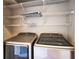 Laundry room featuring modern, front-loading, machines and overhead wire shelving at 7700 Carriage Homes Dr # 4, Orlando, FL 32819