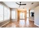 Bright living room featuring neutral walls, terra cotta tile floors, plantation shutters, and modern lighting fixture at 7700 Carriage Homes Dr # 4, Orlando, FL 32819