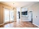 Open-concept living area with sliding glass doors, stylish light fixture, and tile flooring adjoining a kitchen at 7700 Carriage Homes Dr # 4, Orlando, FL 32819