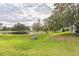 A picturesque view of a community pond surrounded by mature trees and manicured lawns at 7700 Carriage Homes Dr # 4, Orlando, FL 32819