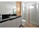 Modern bathroom featuring a sleek vanity with a black countertop and a glass-enclosed shower at 836 Desert Mountain Ct, Reunion, FL 34747