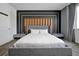 Modern bedroom with a gray upholstered bed, wood-paneled headboard, and ambient lighting at 836 Desert Mountain Ct, Reunion, FL 34747