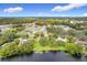 Aerial view of homes nestled among lush greenery with a picturesque lake in the foreground at 119 Lake Dr, Oviedo, FL 32765