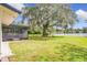 Backyard with screened lanai and large oak tree with Spanish moss overlooking a serene lake at 119 Lake Dr, Oviedo, FL 32765