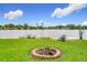 Backyard featuring a circular fire pit, green lawn, and a serene lake view at 119 Lake Dr, Oviedo, FL 32765