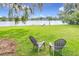 Lush backyard overlooking the lake with relaxing patio chairs at 119 Lake Dr, Oviedo, FL 32765