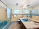 Bathroom features vintage blue tile and sliding shower door, as well as sink with long vanity at 119 Lake Dr, Oviedo, FL 32765