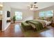 Relaxing bedroom featuring hardwood floors, a ceiling fan, and natural light from two windows at 119 Lake Dr, Oviedo, FL 32765