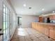 Eat-in kitchen features tile floors, wood cabinets, and a breakfast bar looking to French doors to the backyard at 119 Lake Dr, Oviedo, FL 32765