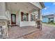 Brick porch with stone columns and a brown front door at 15583 Hamlin Blossom Ave, Winter Garden, FL 34787