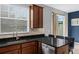 Modern kitchen with stainless steel appliances, dark cabinets, and granite countertops near a sunny window at 2129 Victoria Glen Dr, Sanford, FL 32773