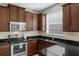 Close-up of kitchen featuring dark wood cabinets, granite countertops, and a stainless steel sink at 2129 Victoria Glen Dr, Sanford, FL 32773