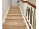 Carpeted staircase featuring painted risers, stringers, and a dark wood handrail at 2129 Victoria Glen Dr, Sanford, FL 32773