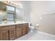 Bathroom with double sinks, wood cabinets, and a tiled floor at 3904 Plantation Blvd, Leesburg, FL 34748