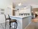 Modern kitchen with white cabinets, quartz countertops, and a breakfast bar at 3904 Plantation Blvd, Leesburg, FL 34748