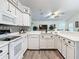 Modern kitchen with white cabinets, quartz countertops, and tile floors at 3904 Plantation Blvd, Leesburg, FL 34748