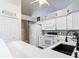 Updated kitchen featuring white cabinets, black sink, and stainless steel appliances at 3904 Plantation Blvd, Leesburg, FL 34748