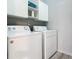 Laundry room with washer, dryer, and overhead cabinets at 3904 Plantation Blvd, Leesburg, FL 34748