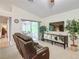 Living room with sliding doors leading to a patio and a brown leather couch at 3904 Plantation Blvd, Leesburg, FL 34748