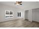 Bedroom featuring light wood flooring, a ceiling fan, two windows, and an open closet at 1740 Palm Rd, Ormond Beach, FL 32174