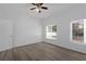 Bright bedroom with wood-look floors, large window, and ceiling fan at 1740 Palm Rd, Ormond Beach, FL 32174