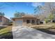 View of the home's long driveway leading up to the garage with an exterior side-on view of the house at 1740 Palm Rd, Ormond Beach, FL 32174