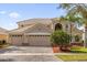 Two-story house with three-car garage, landscaping, and a brick paved driveway at 3814 Golden Feather Way, Kissimmee, FL 34746