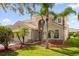 Two-story house with palm trees, landscaping, and a brick paved driveway at 3814 Golden Feather Way, Kissimmee, FL 34746