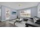 Living room with gray sectional sofa and large window at 3814 Golden Feather Way, Kissimmee, FL 34746