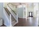 Grand foyer featuring a staircase with white railings, dark wood floors, a chandelier, and a front door at 4431 Rock Hill Loop, Apopka, FL 32712