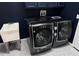 Modern laundry room with LG Signature washer and dryer, utility sink, and dark blue cabinets at 4431 Rock Hill Loop, Apopka, FL 32712