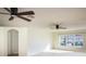 Large living room featuring a window and two ceiling fans at 4431 Rock Hill Loop, Apopka, FL 32712