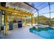 Outdoor kitchen with pergola and adjacent pool and spa at 4431 Rock Hill Loop, Apopka, FL 32712