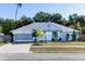Charming single-story home showcasing a light blue exterior, well-manicured landscaping, and a two-car garage at 1269 Buccaneer Ave, Deltona, FL 32725