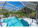 Inviting screened-in pool area with tiled trim, tropical plants and a beautiful water feature at 1269 Buccaneer Ave, Deltona, FL 32725