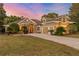 Charming tan two-story home with stone accents, well-manicured lawn, and a spacious driveway at 17429 Cobblestone Ln, Clermont, FL 34711