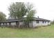 A sprawling single story white brick home has mature trees in the front yard at 3555 E Johnson Ave, Haines City, FL 33844