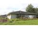 Brick exterior of a single story house showing the roof, small windows, and overgrown landscaping at 3555 E Johnson Ave, Haines City, FL 33844