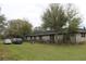The long ranch style brick home has mature trees and multiple parked cars in the front at 3555 E Johnson Ave, Haines City, FL 33844