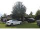 Exterior view of the home with two vehicles parked in front and overgrown grass at 3555 E Johnson Ave, Haines City, FL 33844