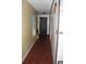 Narrow hallway with tile flooring and neutral paint, connecting different areas at 3555 E Johnson Ave, Haines City, FL 33844