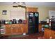 Kitchen has wood cabinets, black appliances, tile floors, and a broom on the floor at 3555 E Johnson Ave, Haines City, FL 33844